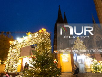 Visitors check the stalls selling Christmas decorations at Cologne Christmas in front of Dam Cathedral in Cologne, Germany, on November 18,...