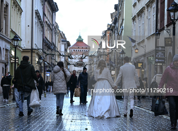 KRAKOW, POLAND - NOVEMBER 18:   
A newlywed couple strolls along Floriańska Street on a cold, wintery Monday afternoon, seen on November 17,...