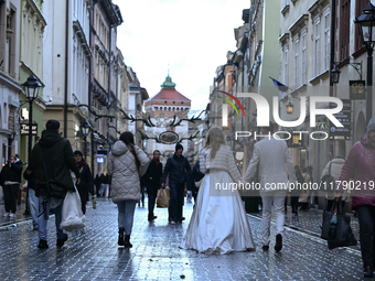 KRAKOW, POLAND - NOVEMBER 18:   
A newlywed couple strolls along Floriańska Street on a cold, wintery Monday afternoon, seen on November 17,...