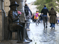 KRAKOW, POLAND - NOVEMBER 18:   
View of Piotr Skrzynecki's statue in Krakow's UNESCO-listed Market Square on a rainy and cold November afte...