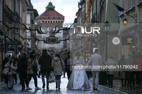 KRAKOW, POLAND - NOVEMBER 18:   
A newlywed couple strolls along Floriańska Street on a cold, wintery Monday afternoon, seen on November 17,...