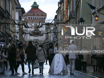 KRAKOW, POLAND - NOVEMBER 18:   
A newlywed couple strolls along Floriańska Street on a cold, wintery Monday afternoon, seen on November 17,...