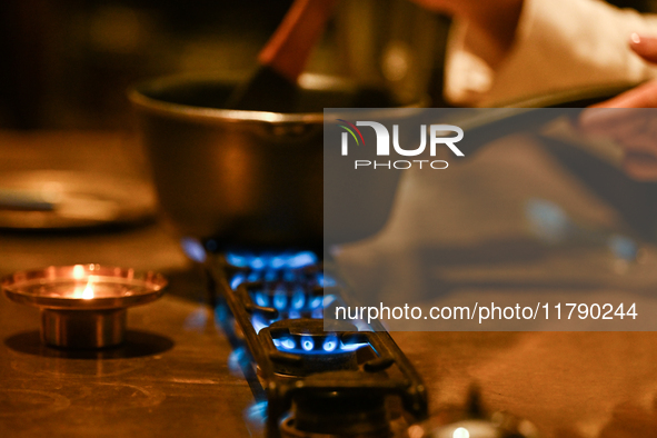 KRAKOW, POLAND - NOVEMBER 18:   
Staff member melting chocolate over natural gas burners on a stove in a Krakow cafe, showcasing the role of...