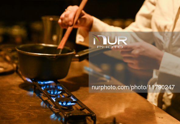 KRAKOW, POLAND - NOVEMBER 18:   
Staff member melting chocolate over natural gas burners on a stove in a Krakow cafe, showcasing the role of...