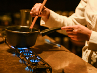 KRAKOW, POLAND - NOVEMBER 18:   
Staff member melting chocolate over natural gas burners on a stove in a Krakow cafe, showcasing the role of...