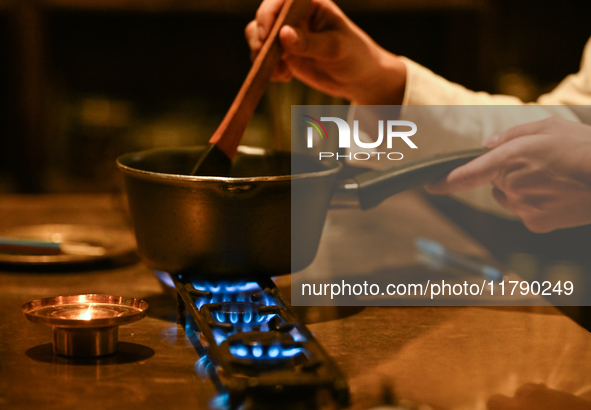 KRAKOW, POLAND - NOVEMBER 18:   
Staff member melting chocolate over natural gas burners on a stove in a Krakow cafe, showcasing the role of...