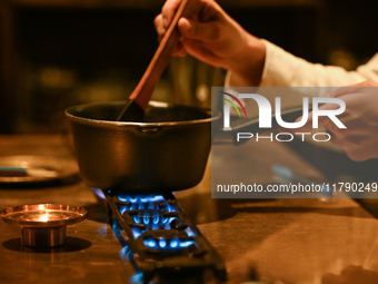 KRAKOW, POLAND - NOVEMBER 18:   
Staff member melting chocolate over natural gas burners on a stove in a Krakow cafe, showcasing the role of...