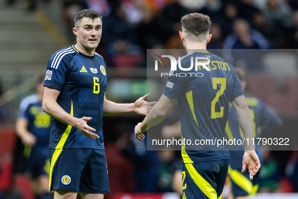 John Souttar (L) and  Anthony Ralston talk during the  UEFA Nations League 2024 League A Group A1 match between Poland and Scotland, at the...