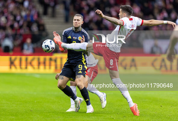 Lyndon Dykes , Jakub Moder  during UEFA Nations League match Poland vs Scotland in Warsaw Poland on 18 November 2024. 