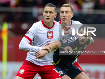 Piotr Zielinski, Adam Buksa and John McGinn in action during the  UEFA Nations League 2024 League A Group A1 match between Poland and Scotla...