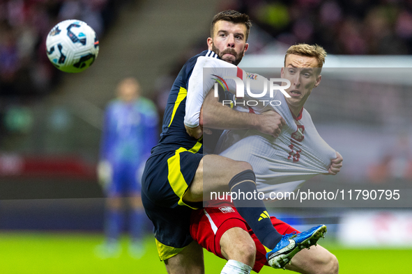 Grant Hanley and Adam Buksa in action during the  UEFA Nations League 2024 League A Group A1 match between Poland and Scotland, at the  PGE...