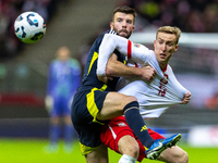 Grant Hanley and Adam Buksa in action during the  UEFA Nations League 2024 League A Group A1 match between Poland and Scotland, at the  PGE...