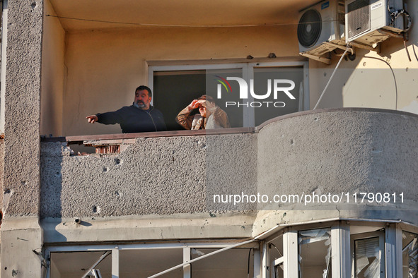 People are seen on the balcony of a residential building damaged by Russian rocket fire in Odesa, Ukraine, on November 18, 2024. NO USE RUSS...