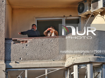 People are seen on the balcony of a residential building damaged by Russian rocket fire in Odesa, Ukraine, on November 18, 2024. NO USE RUSS...