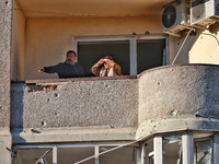 People are seen on the balcony of a residential building damaged by Russian rocket fire in Odesa, Ukraine, on November 18, 2024. NO USE RUSS...