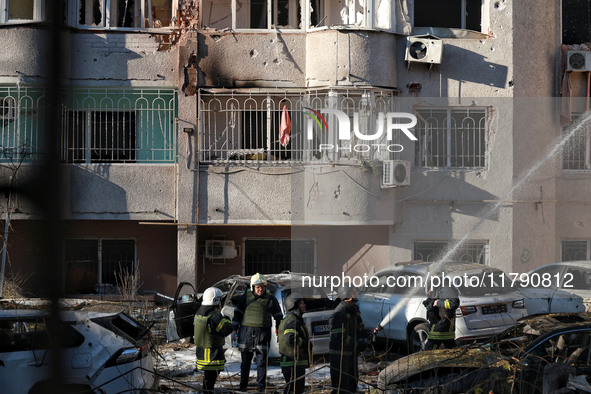 Rescuers stand next to the cars damaged by Russian rocket fire in Odesa, Ukraine, on November 18, 2024. NO USE RUSSIA. NO USE BELARUS. 