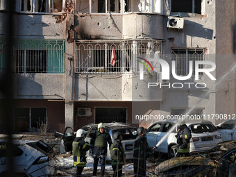 Rescuers stand next to the cars damaged by Russian rocket fire in Odesa, Ukraine, on November 18, 2024. NO USE RUSSIA. NO USE BELARUS. (