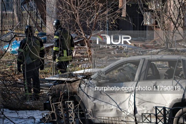 Rescuers stand next to a car mutilated by Russian rocket fire in Odesa, Ukraine, on November 18, 2024. NO USE RUSSIA. NO USE BELARUS. 