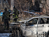 Rescuers stand next to a car mutilated by Russian rocket fire in Odesa, Ukraine, on November 18, 2024. NO USE RUSSIA. NO USE BELARUS. (