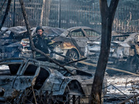 A rescuer stands next to the cars damaged by Russian rocket fire in Odesa, Ukraine, on November 18, 2024. NO USE RUSSIA. NO USE BELARUS. (