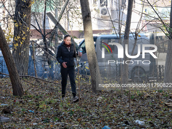 A woman stands against the background of cars damaged by Russian rocket fire in Odesa, Ukraine, on November 18, 2024. NO USE RUSSIA. NO USE...