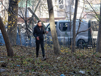 A woman stands against the background of cars damaged by Russian rocket fire in Odesa, Ukraine, on November 18, 2024. NO USE RUSSIA. NO USE...