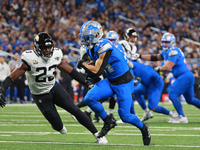 DETROIT,MICHIGAN-November 17: Detroit Lions wide receiver Amon-Ra St. Brown (14) carries the ball during the first half of an NFL football g...