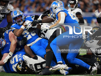 DETROIT,MICHIGAN-November 17: Detroit Lions running back Jahmyr Gibbs (26) is tackled during the second half of an NFL football game between...