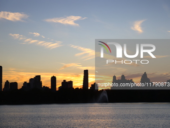 The sunset appears in the west across the Jacqueline Kennedy Onassis Reservoir in Central Park while the fall weather occurs in New York, N....