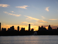 The sunset appears in the west across the Jacqueline Kennedy Onassis Reservoir in Central Park while the fall weather occurs in New York, N....