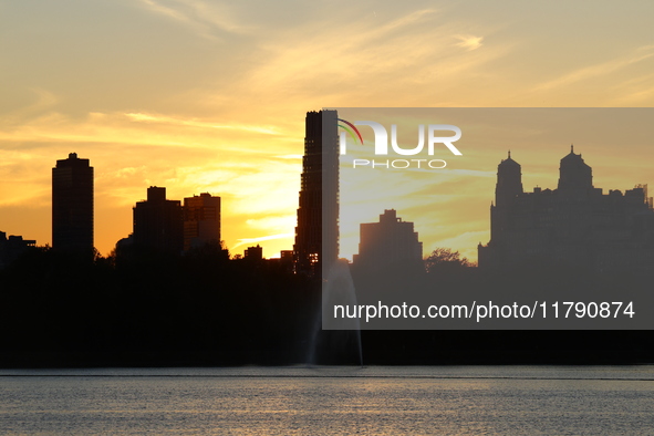 The sunset appears in the west across the Jacqueline Kennedy Onassis Reservoir in Central Park while the fall weather occurs in New York, N....