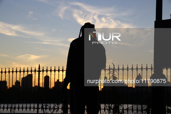 People take photos of the Jacqueline Kennedy Onassis Reservoir in Central Park while experiencing the fall weather in New York, N.Y., on Nov...