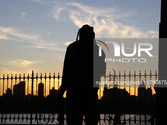 People take photos of the Jacqueline Kennedy Onassis Reservoir in Central Park while experiencing the fall weather in New York, N.Y., on Nov...