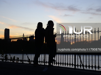 People take photos of the Jacqueline Kennedy Onassis Reservoir in Central Park while experiencing the fall weather in New York, N.Y., on Nov...