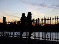 People take photos of the Jacqueline Kennedy Onassis Reservoir in Central Park while experiencing the fall weather in New York, N.Y., on Nov...