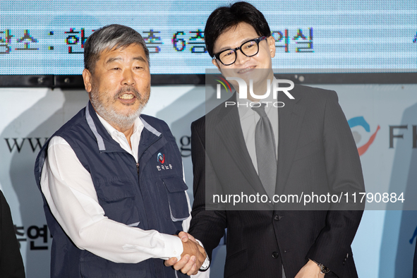 Han Dong-hoon, leader of the People Power Party, and Kim Dong-myung, chairman of the Korean Federation of Trade Unions, shake hands during a...