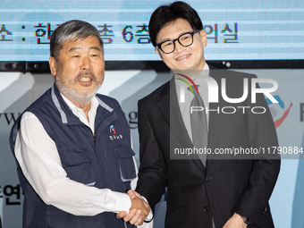 Han Dong-hoon, leader of the People Power Party, and Kim Dong-myung, chairman of the Korean Federation of Trade Unions, shake hands during a...