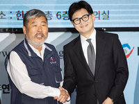 Han Dong-hoon, leader of the People Power Party, and Kim Dong-myung, chairman of the Korean Federation of Trade Unions, shake hands during a...