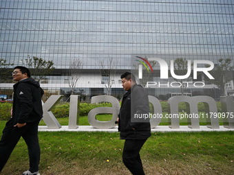 In Nanjing, China, on November 19, 2024, citizens walk past the East China headquarters building of Xiaomi Group. Xiaomi Group announces tha...