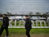 In Nanjing, China, on November 19, 2024, citizens walk past the East China headquarters building of Xiaomi Group. Xiaomi Group announces tha...