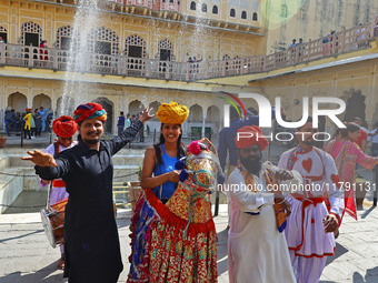 Tourists dance with Rajasthani folk artists at the historical Hawa Mahal on the occasion of the 297th Foundation of 'Pinkcity' in Jaipur, Ra...