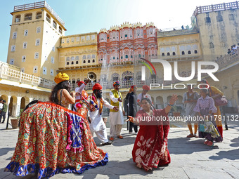 Tourists dance with Rajasthani folk artists at the historical Hawa Mahal on the occasion of the 297th Foundation of 'Pinkcity' in Jaipur, Ra...