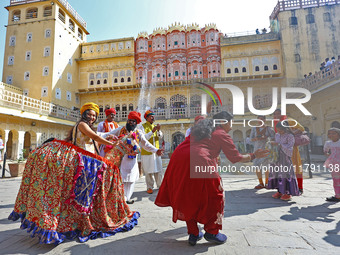 Tourists dance with Rajasthani folk artists at the historical Hawa Mahal on the occasion of the 297th Foundation of 'Pinkcity' in Jaipur, Ra...