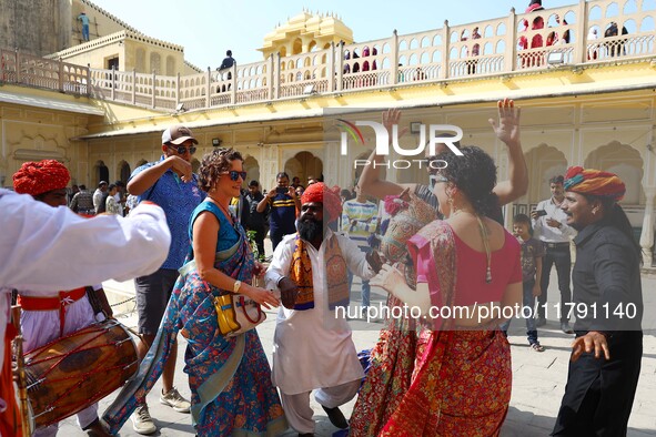 Tourists dance with Rajasthani folk artists at the historical Hawa Mahal on the occasion of the 297th Foundation of 'Pinkcity' in Jaipur, Ra...