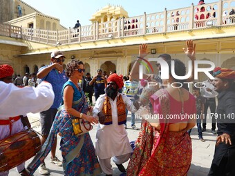 Tourists dance with Rajasthani folk artists at the historical Hawa Mahal on the occasion of the 297th Foundation of 'Pinkcity' in Jaipur, Ra...