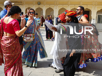 Tourists dance with Rajasthani folk artists at the historical Hawa Mahal on the occasion of the 297th Foundation of 'Pinkcity' in Jaipur, Ra...