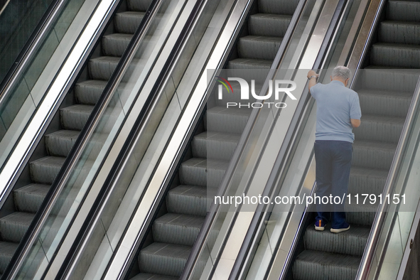 A man ascends the escalator inside the Antwerp Opera Metro Station in Antwerp, Belgium, on July 31, 2023. The scene captures the rhythm of d...