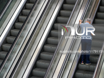 A man ascends the escalator inside the Antwerp Opera Metro Station in Antwerp, Belgium, on July 31, 2023. The scene captures the rhythm of d...