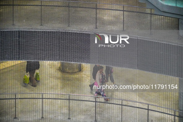 Commuters navigate the underground levels of the Opera Metro Station in Antwerp, Belgium, on July 31, 2023. The vertical mesh and curved rai...