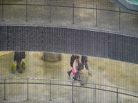 Commuters navigate the underground levels of the Opera Metro Station in Antwerp, Belgium, on July 31, 2023. The vertical mesh and curved rai...